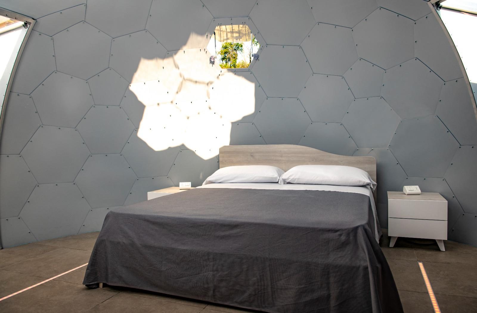 Pannelli LED esagonali accesi sopra il letto